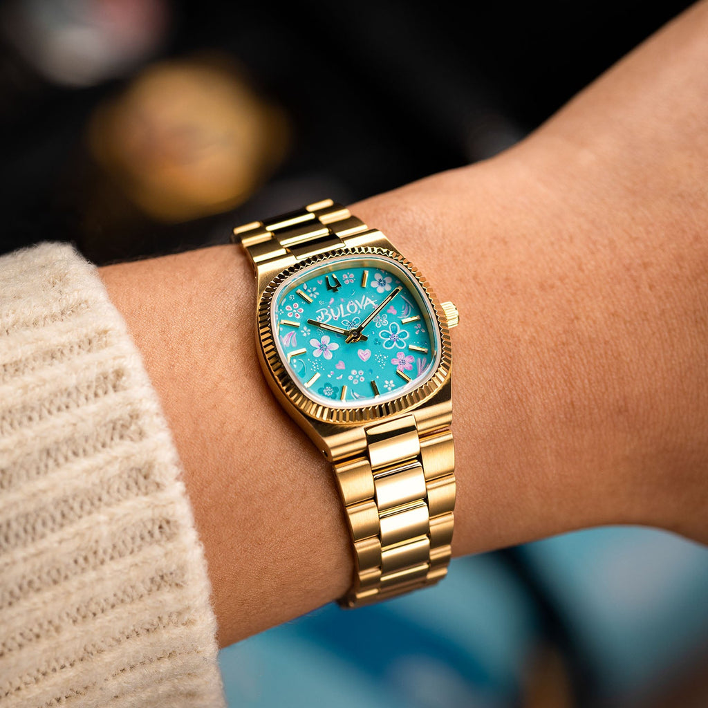 Bulova Super Seville Jardin Bleu — Gold-tone case and integrated three-link bracelet angled on the wrist, hand-painted turquoise garden across the custom dial, bespoke by IFL Watches.