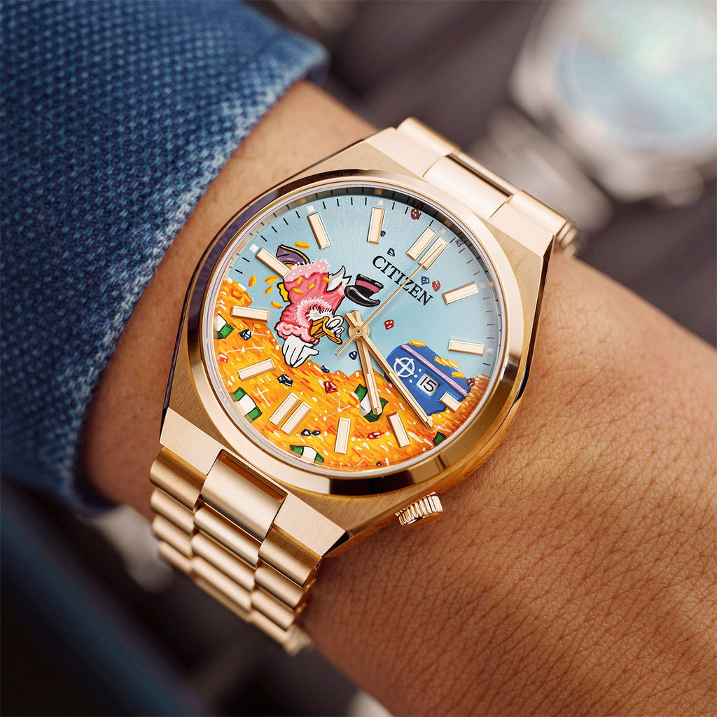 Citizen Tsuyosa Dive in Time on wrist — crown-side view of the hand-painted dial with blue sky, scattered coins, and steel vault near the date window at 3 o'clock on a 40mm rose gold automatic, a bespoke timepiece by IFL Watches.