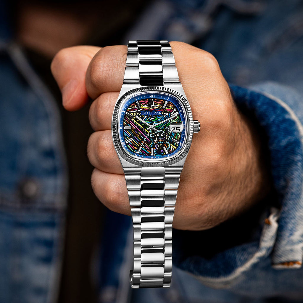 Bulova Super Seville Scream — Held in a closed fist toward the camera, full steel bracelet hanging below the custom dial, limited edition timepiece by IFL Watches