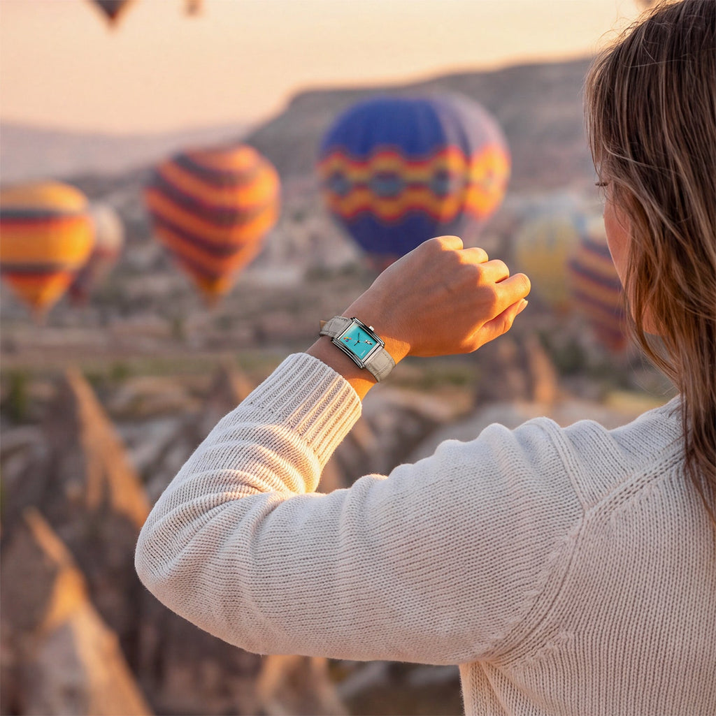 Laphont Bloc Cloudling — Raised on the wrist of a woman in a cream knit sweater as hot-air balloons drift over a rocky valley at sunrise, a hand-painted limited edition timepiece by IFL Watches
