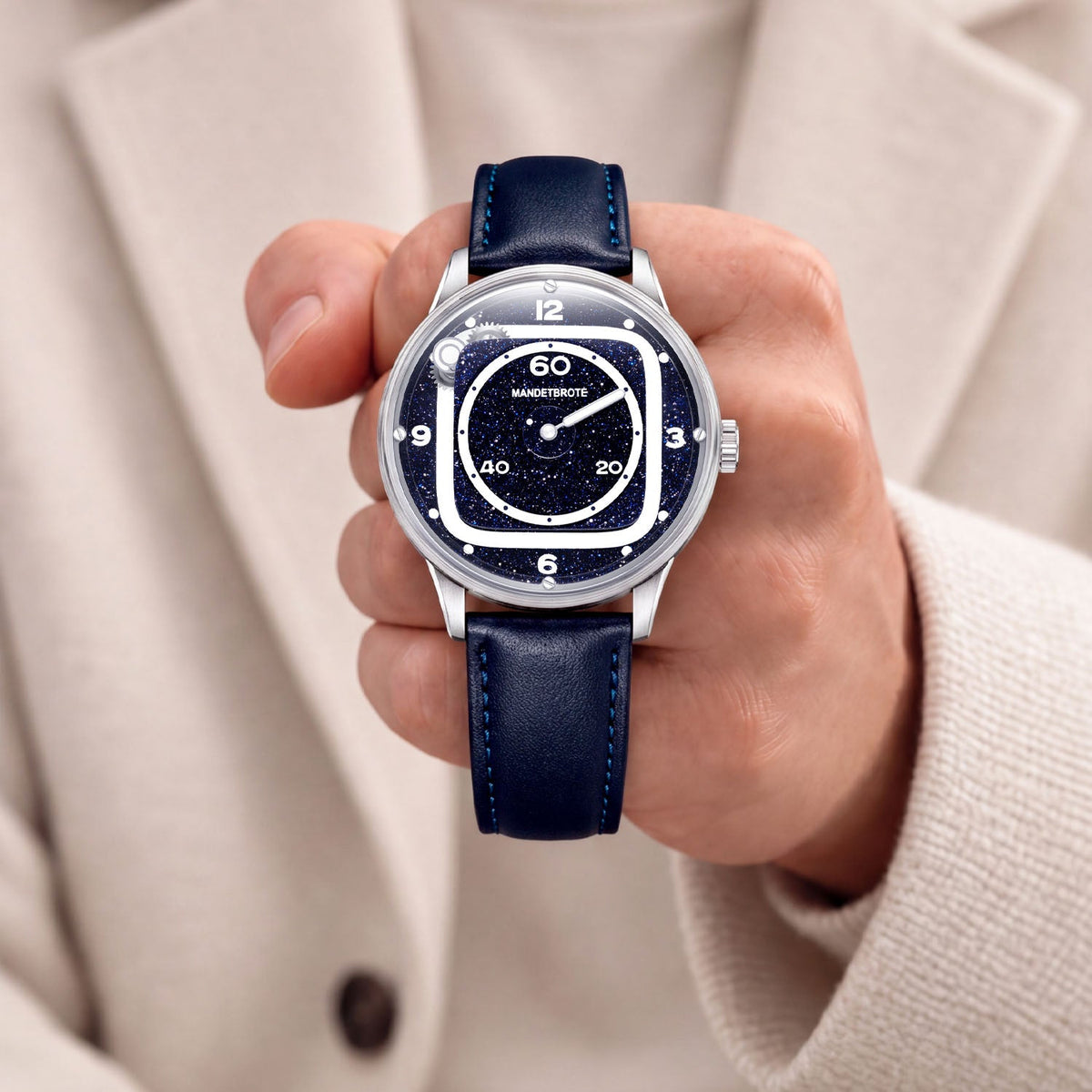 Mandetbrote Orbital II Blue — Held in hand against a cream knit sweater, showing the star-flecked dial, available at IFL Watches.