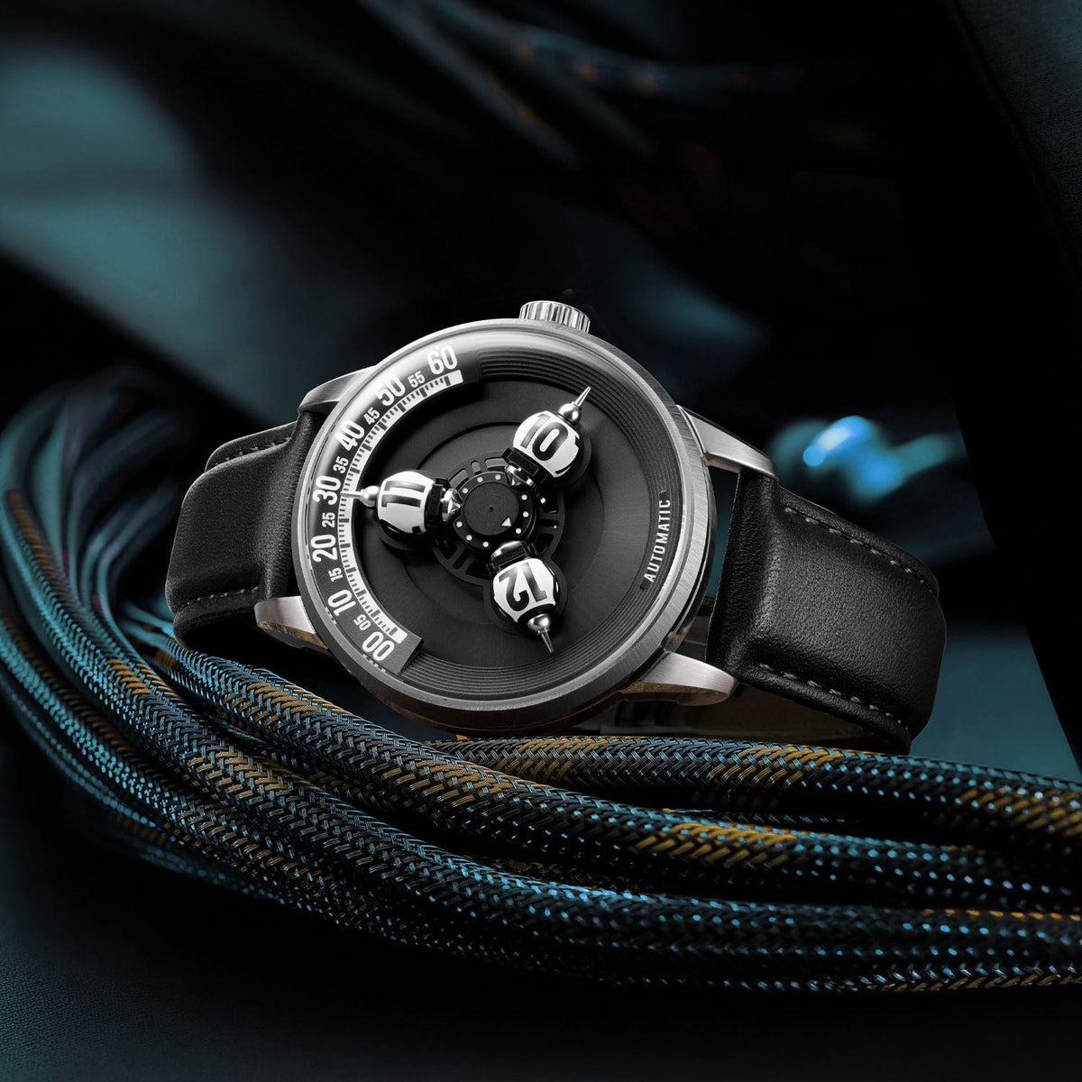 Vortichron Timeorb Midnight Black — Three-quarter view resting on braided cord in teal light, available at IFL Watches.